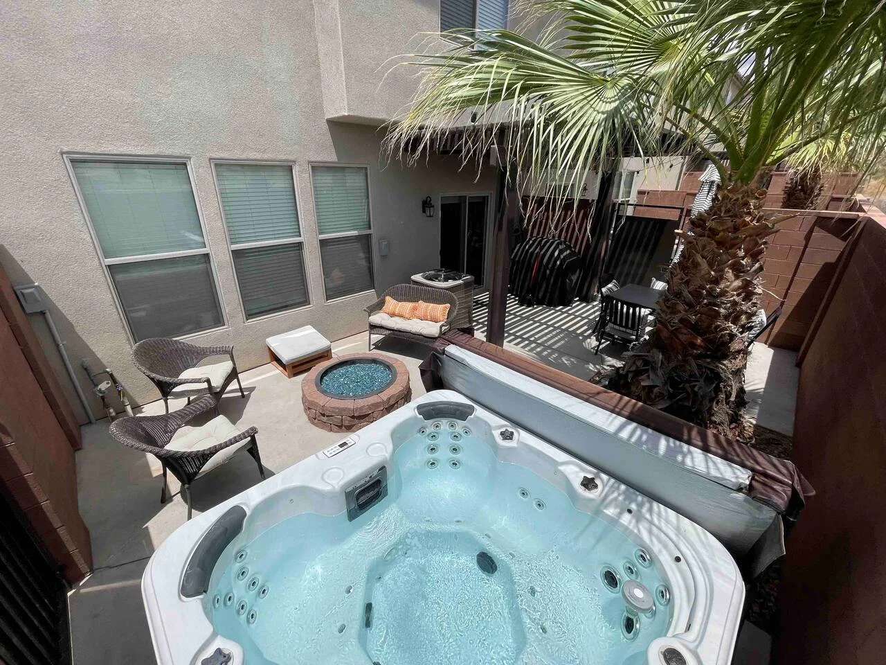 Private patio at Saint George Escape with an open hot tub, firepit and seating